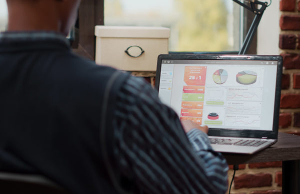 Sales assistant planning business charts on digital laptop, working with e commerce and e shopping management in company office. Manager using statistics to develop creative project.